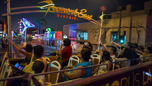 Passengers enjoying the Panoramic Night Tour from the Big Bus Las Vegas, marveling at the city's dazzling lights and iconic landmarks.